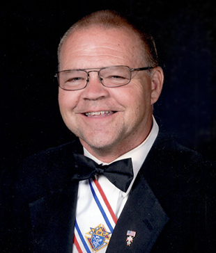 portrait of Michael Kalal in a black suit with a Knights of Columbus pin